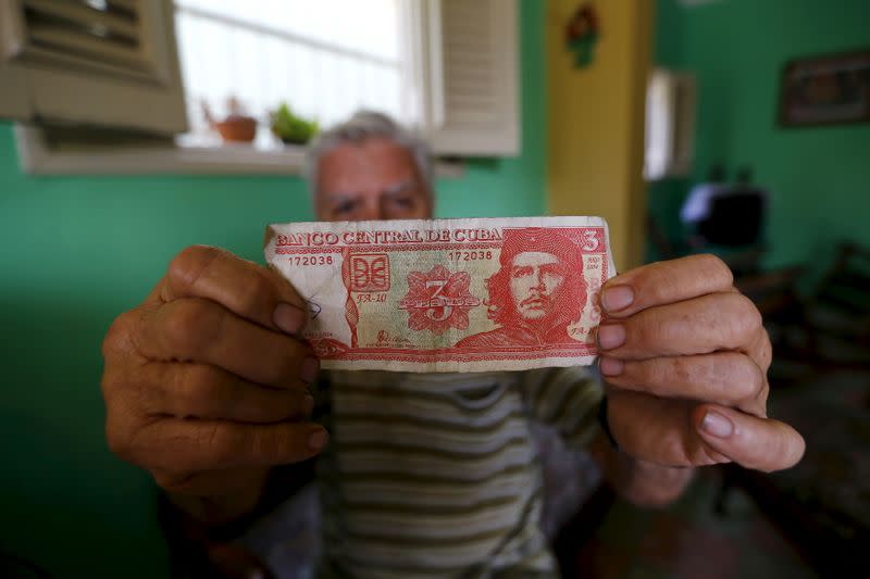 FOTO DE ARCHIVO. Un hombre muestra un billete impreso con una imagen del fallecido héroe revolucionario Ernesto "Che" Guevara en La Habana, Cuba