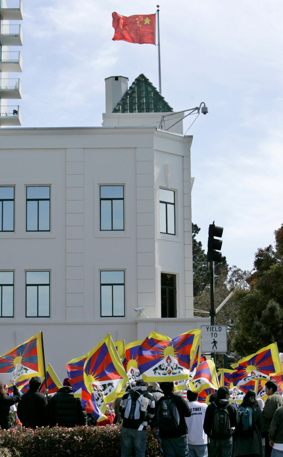 FILE - In this April 8, 2008 file photo, Tibetans and supporters waves Tibetan flags at a rally in protest of China's Olympic torch at the Chinese Consulate in San Francisco. The Chinese consulate in San Francisco is harboring a Chinese researcher who the FBI says lied about her military background. (AP Photo/Jeff Chiu)