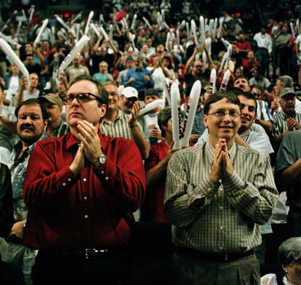 ARCHIVO - En esta foto de archivo del 27 de mayo de 1999, Paul Allen (izquierda) y Bill Gates, cofundadores de Microsoft, aplauden durante un partido de los Trail Blazers de Portland ante el Jazz de Utah (AP Foto/Steve Slocum, archivo)