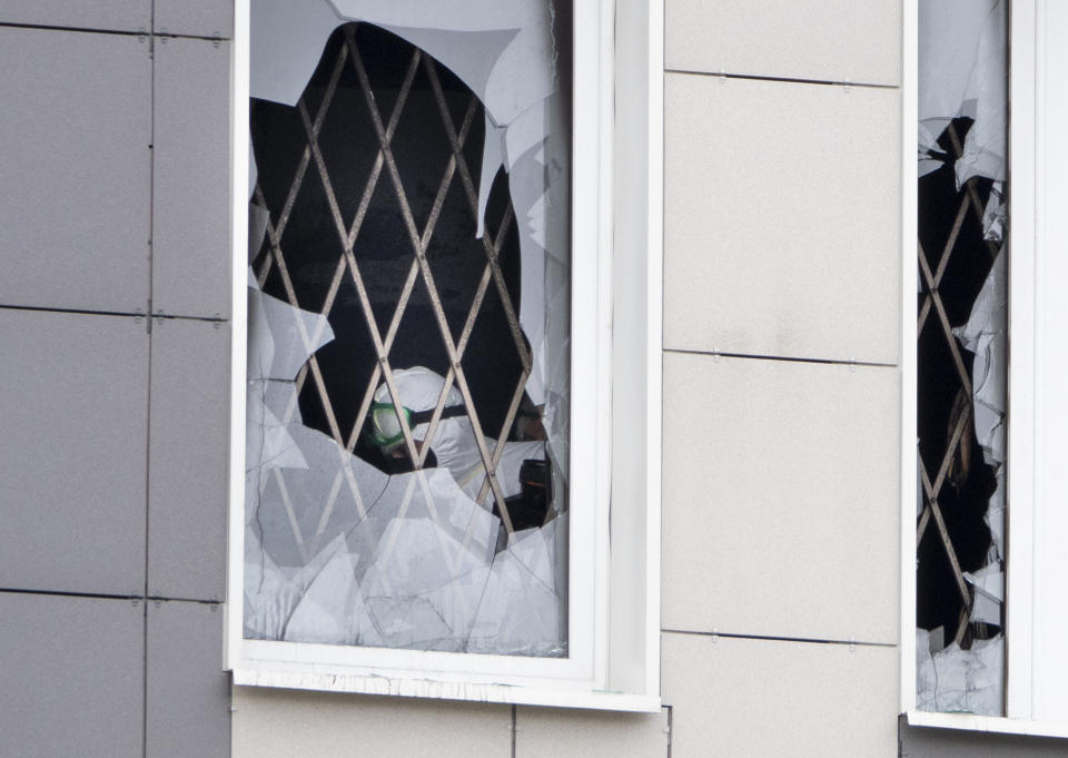 An investigator is seen through a broken window at the scene of a fire at St. George Hospital in St. Petersburg, Russia, Tuesday, May 12, 2020. A fire at St. George Hospital has killed five coronavirus patients. Russian emergency officials said all five had been put on ventilators. The emergency officials told the state Tass new agency the fire broke out in an intensive care unit and was put out within half an hour. (AP Photo/Dmitry Lovetsky)