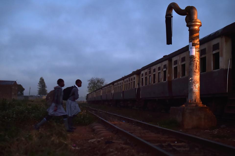 Two school girls walk towards a commuter train in Kikuyu, Kenya, on September 13, 2016. The railway in Kenya has a long history, with the British laying the country's first rail in 1896.&nbsp;