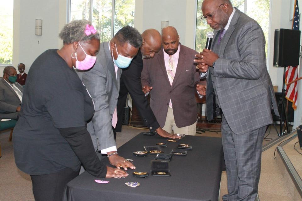 Bishop Christopher Stokes, right, and other members of the clergy pray over badges during the Blessing of the Badges service held Sunday at DaySpring Baptist Church. The service was hosted by the Atkins Warren chapter of the National Organization of Black Law Enforcement Executives, of which Stokes is the chaplain.