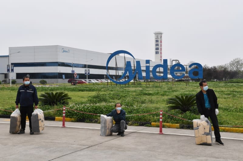 Workers wearing protective masks are seen outside Midea factory in Wuhan