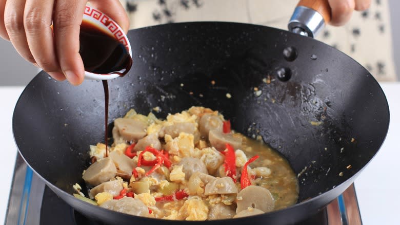 Adding sauce into a wok