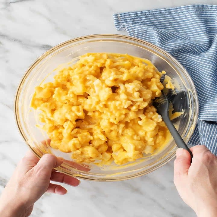 Mixing cauliflower with vegan cheese sauce.