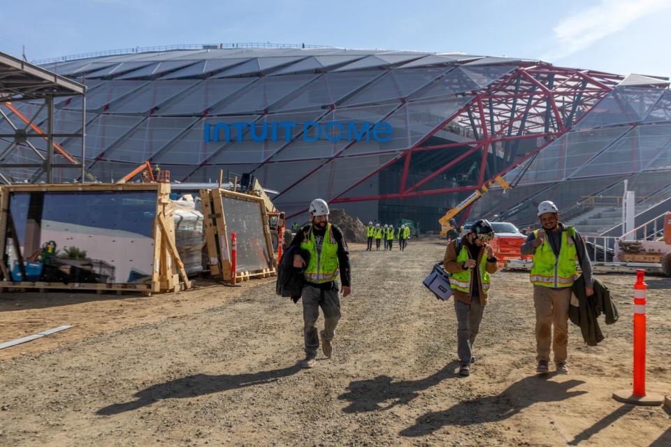 Construction workers move about the site of the Intuit Dome, which is on a tight schedule to be completed by July.