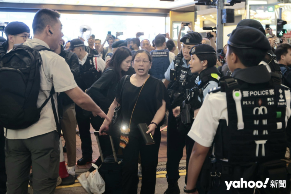 The lady in black was taken away with her mobile phone in hand