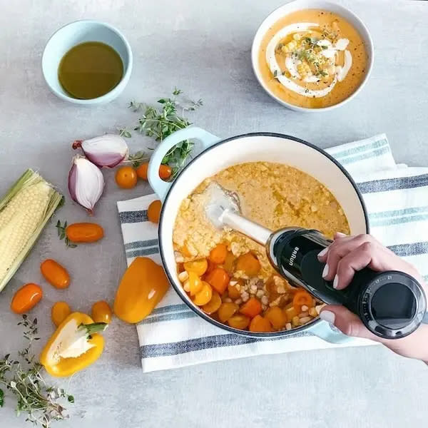 A woman using a immersion blender