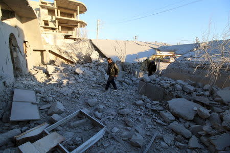 Residents inspect damage after airstrikes by pro-Syrian government forces in Anadan city, about 10 kilometers away from the towns of Nubul and Zahraa, Northern Aleppo countryside, Syria February 3, 2016. REUTERS/Abdalrhman Ismail