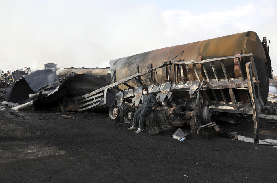 A man sits on his charred fuel tanker in Kabul, Afghanistan, Sunday, May 2, 2021. A fire roared through several fuel tankers on the northern edge of the Afghan capital late Saturday, injuring at least 10 people and plunging much of the city into darkness, officials said. (AP Photo/Rahmat Gul)