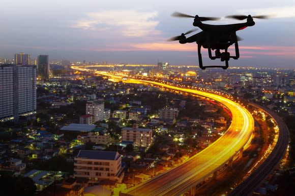 A drone flying over a city at dusk