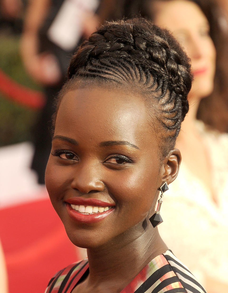 Lupita Nyong'o </br> <em>Use a smoothing pomade like <a href="http://local.kmart.com/Smooth-and-Shine-Edge-Smoothing-Pomade--OZ-BOX/p-038W005068955001P?st=7777&sid=KDx20141117x00002xlpla#!/" target="_blank">Smooth 'N Shine Olive & Tea Tree RevivOil Instant Edge</a> to tame flyaways and keep the braided crown in place. </em>