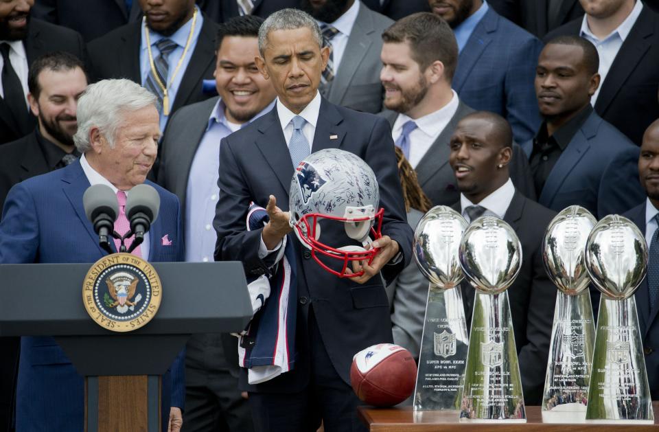 President Barack Obama looks over a signed New England Patriots football helmet presented to him by New England Patriots owner Robert Kraft, left, during a ceremony on the South Lawn of the White House in Wasington, Thursday, April 23, 2015, where the president honored the Super Bowl Champion New England Patriots for their Super Bowl XLIX victory. (AP Photo/Pablo Martinez Monsivais)