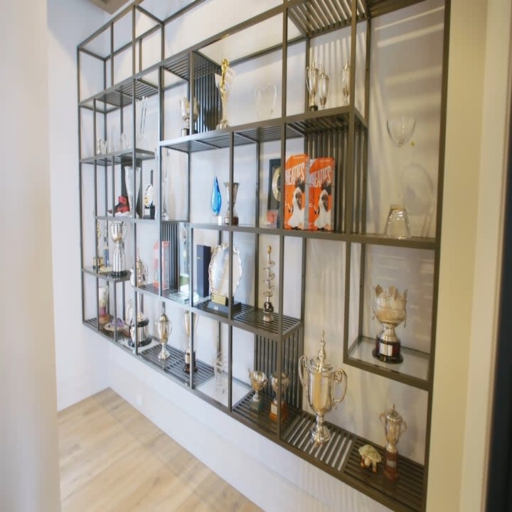 There are many trophies set up on shelves