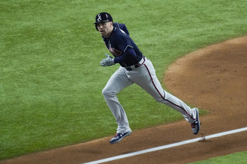 Atlanta Braves' Freddie Freeman watches his home run during the first inning in Game 1 of a baseball National League Championship Series against the Los Angeles Dodgers Monday, Oct. 12, 2020, in Arlington, Texas.(AP Photo/Sue Ogrocki)