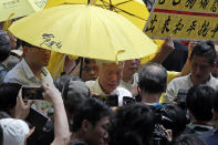 Occupy Central leader Chu Yiu-ming, center, cries as he speaks to media after sentencing at a court in Hong Kong, Wednesday, April 24, 2019. A court in Hong Kong handed down prison sentences of up to 16 months Wednesday to eight leaders of massive 2014 pro-democracy protests on charges of public nuisance offenses. (AP Photo/Kin Cheung)