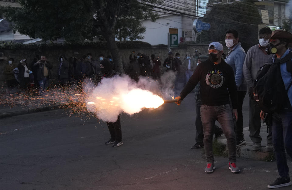 Un manifestante lanza fuegos artificiales hacia los partidarios del líder opositor encarcelado y gobernador de la región de Santa Cruz, Luis Fernando Camacho, durante una protesta en La Paz, Bolivia, el martes 10 de enero de 2023. (AP Foto/Juan Karita)