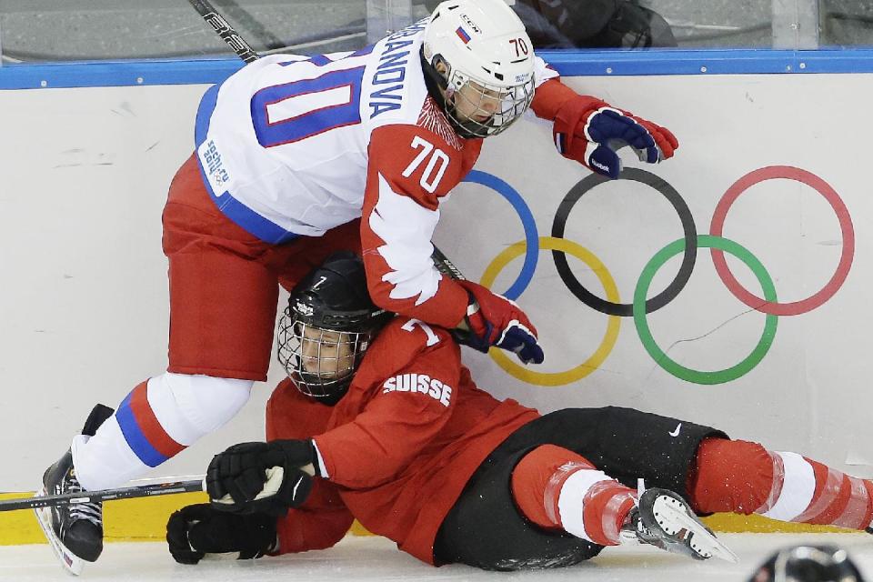 Anna Shibanova of Russia and Lara Stalder of Switzerland collide during the 2014 Winter Olympics women's ice hockey quarterfinal game at Shayba Arena, Saturday, Feb. 15, 2014, in Sochi, Russia. (AP Photo/Matt Slocum)