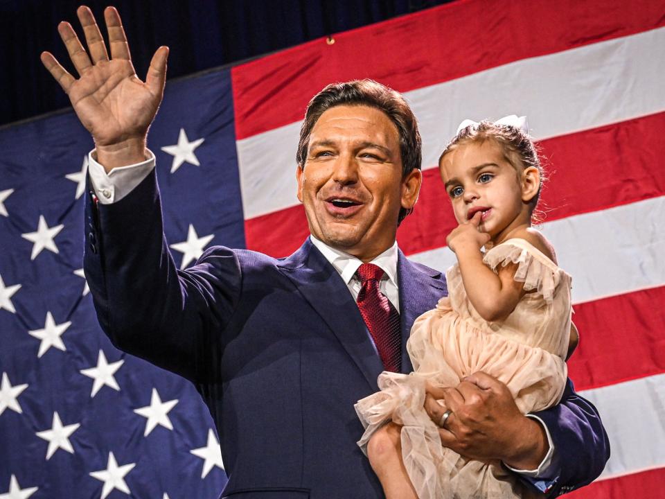 Ron DeSantis waves as he holds his daughter Mamie DeSantis