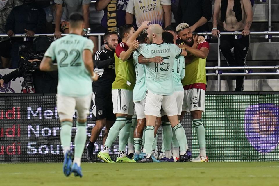 Atlanta United players celebrate as they surround midfielder Thiago Almada after he scored a goal against Orlando City during the second half of an MLS soccer match Wednesday, Sept. 14, 2022, in Orlando, Fla. (AP Photo/John Raoux)