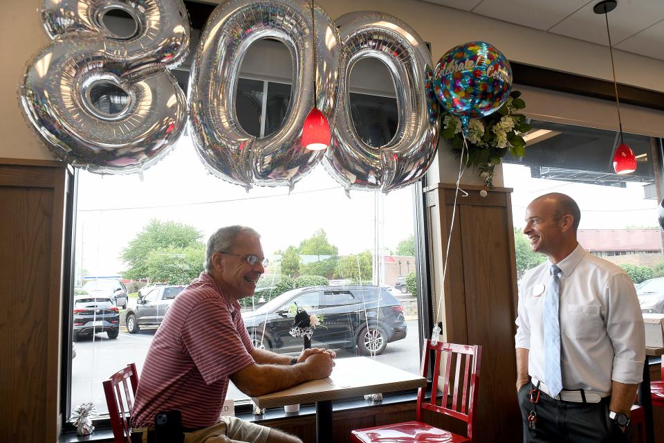 George Rosche, right, owner and operator of the Dressler Road NW Chick-fil-A location, visits with customer John Carucci on Wednesday, the day Carucci ate at the restaurant for the 800th consecutive day. The chain is closed on Sundays so he misses that day each week.