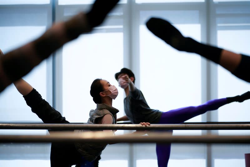 Bailarines de ballet con máscaras practican en un estudio de baile en Shanghái