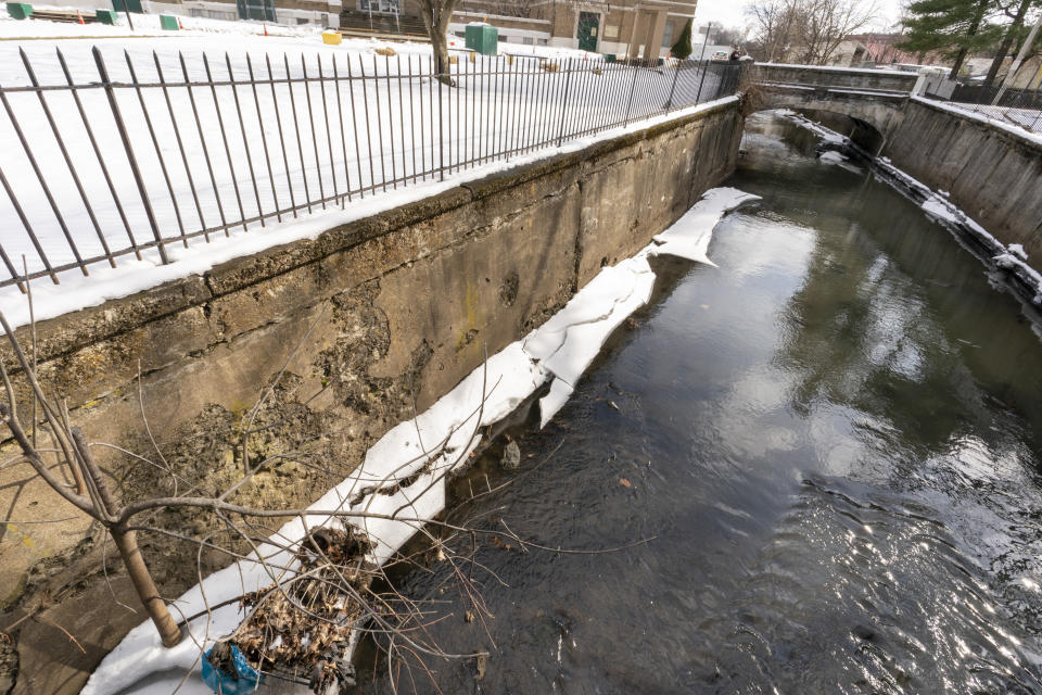 The Fall Kill Creek runs past an eroding retainer wall Tuesday, Jan. 25, 2022, in Poughkeepsie, N.Y. Poughkeepsie was rated by the New York comptroller as the state’s most financially stressed community in 2020. The more than $20 million it is getting from the American Rescue Plan cannot be used to wipe out the deficit, but the city plans to make major improvements to parks and swimming pools, including a complete rebuild of a run-down bathhouse that has been relying on portable toilets. (AP Photo/Mary Altaffer)