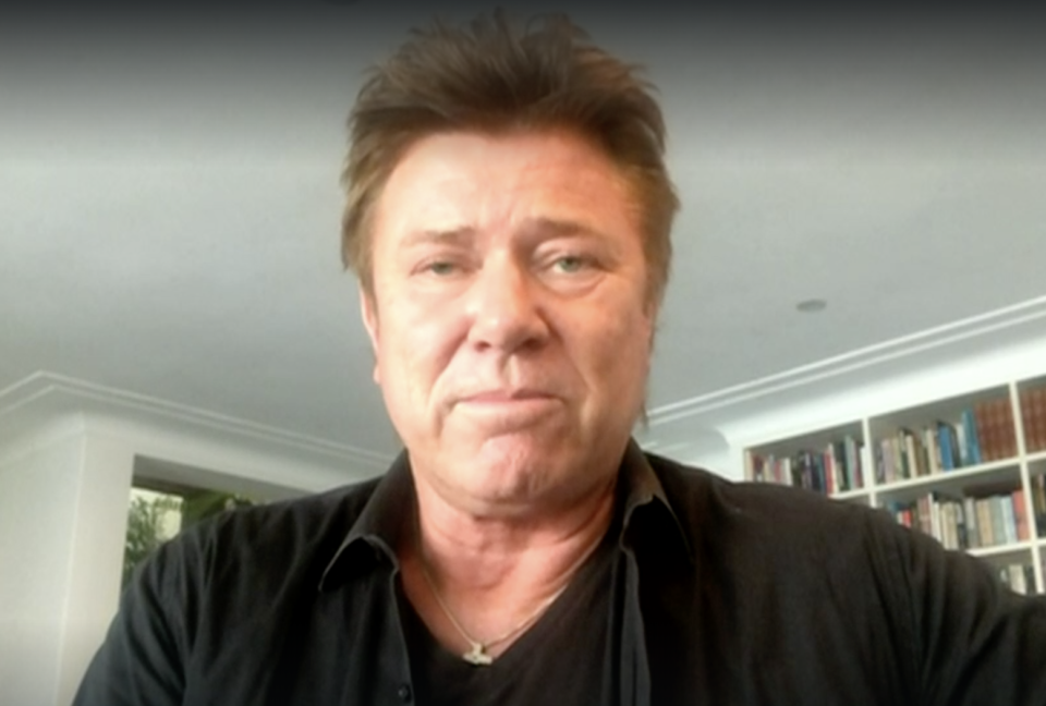 Richard Wilkins in a black top in his Sydney home