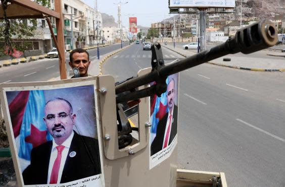 An STC fighter stands guard in Aden with a poster of STC chief Aidarous Zubaidi (NABIL HASAN/AFP/Getty Images)