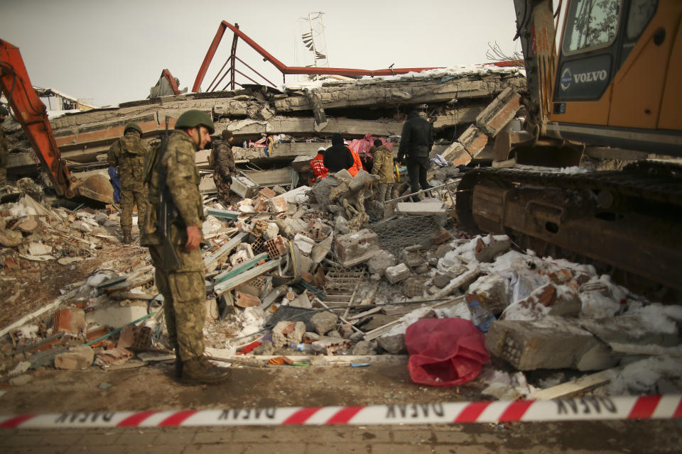 Turkish soldiers search for survivors on a collapsed building in Malatya, eastern Turkey, Wednesday, Feb. 8, 2023. Thinly stretched rescue teams worked through the night in Turkey and Syria, pulling more bodies from the rubble of thousands of buildings toppled by a catastrophic earthquake. The death toll rose Wednesday to more than 9,500, making the quake the deadliest in more than a decade. (AP Photo/Emrah Gurel)