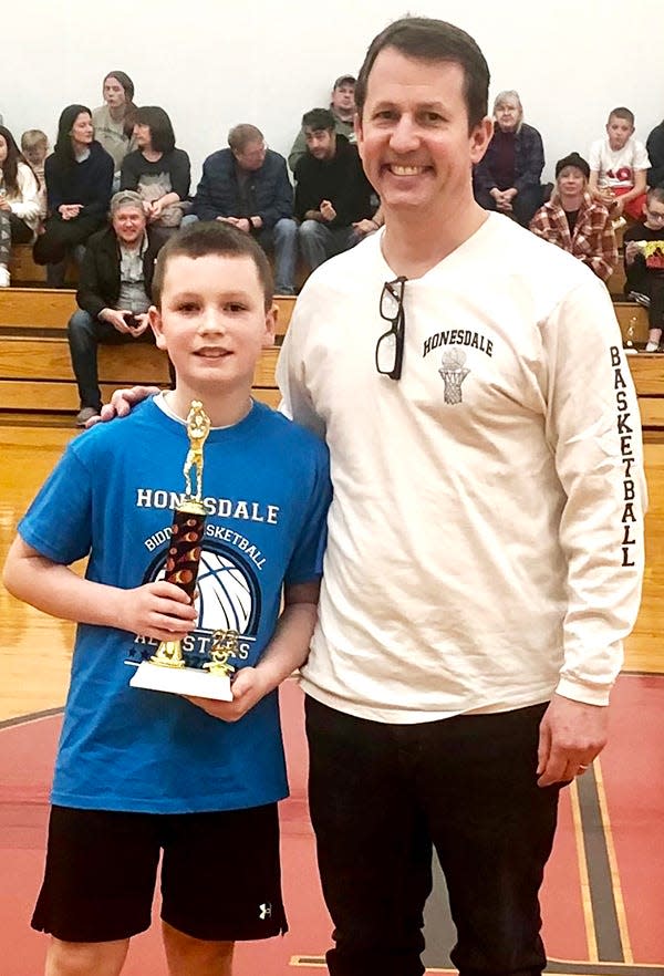 Brody O'Neill won the 2022-23 Ed Martin Sr. Honesdale Biddy Basketball Junior Division free throw shooting contest. Brody is pictured here receiving his trophy from AG Howell.