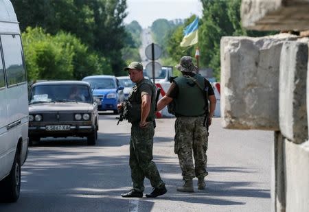 Ukrainian servicemen check cars at a checkpoint near Slaviansk in Donetsk region, Ukraine, June 29, 2016. Picture taken June 29, 2016. To match Insight UKRAINE-CRISIS/ARMS REUTERS/Gleb Garanich
