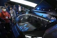 People look in the front cargo area of the Ram 1500 Revolution electric battery powered pickup truck after the Stellantis keynote at the CES tech show Thursday, Jan. 5, 2023, in Las Vegas. (AP Photo/John Locher)