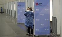 A medical worker waits for patients during start of a mass vaccination campaign against the coronavirus and the COVID-19 disease in Vienna, Austria, Friday, Jan. 15, 2021. Authorities started to vaccinate the most vulnerable people in a coordinated effort. (AP Photo/Ronald Zak)