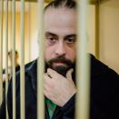 Canadian activist Alexandre Paul listens to a court ruling in a defendants' cage in a court room in St. Petersburg, Russia, Thursday, Nov. 21, 2013. THE CANADIAN PRESS/AP,Greenpeace International, Vladimir Baryshev