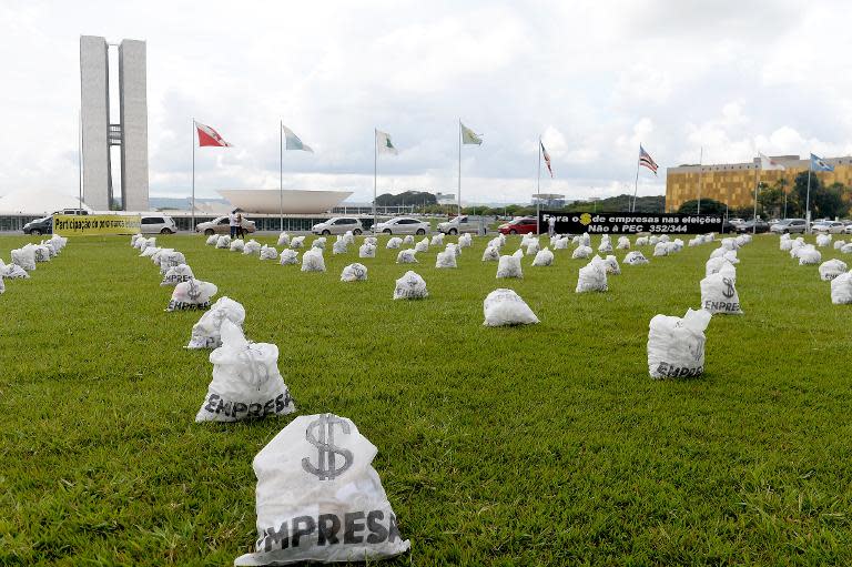 Hundreds of fake money bags representing the donations of companies in election campaigns were distributed in front of the National Congress in Brasilia on March 24, 2015