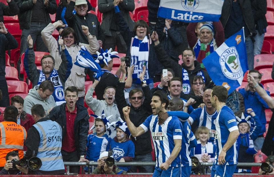Wigan Athletic's Jordi Gomez, left, celebrates with teammates after scoring against Arsenal, during their English FA Cup semifinal soccer match, at the Wembley Stadium in London, Saturday, April 12, 2014. (AP Photo/Bogdan Maran)