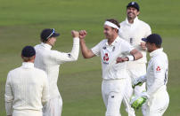 England's Stuart Broad, center, celebrates with teammates the dismissal of West Indies' John Campbell during the third day of the third cricket Test match between England and West Indies at Old Trafford in Manchester, England, Sunday, July 26, 2020. (Michael Steele/Pool via AP)