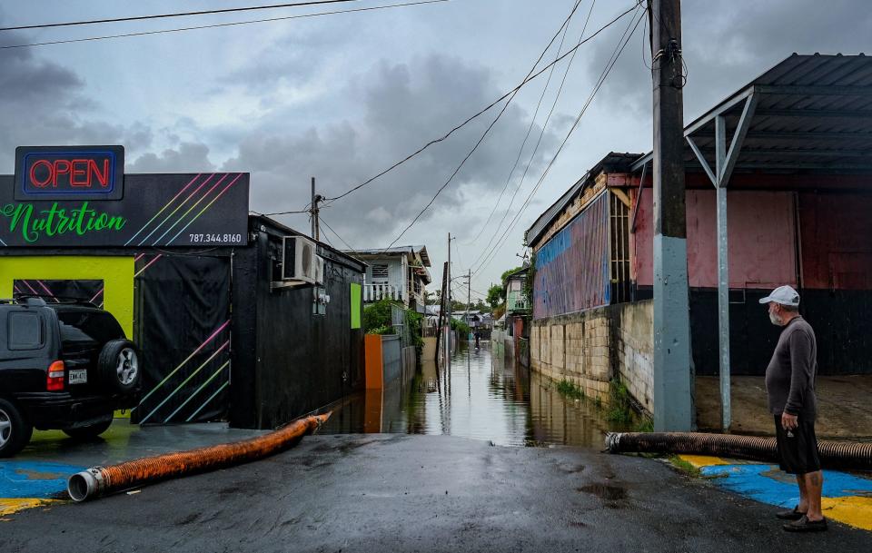 A man looks at a flooded street in the Juana Matos neighborhood of Catano, Puerto Rico, on September 19, 2022, after the passage of Hurricane Fiona. / Credit: AFP via Getty Images