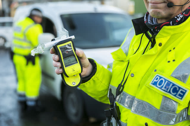 A PSNI Road Policing officer holds an operational breathalyser during a random drink driving checkpoint in Belfast.