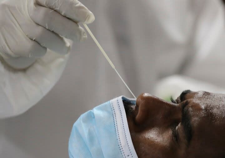 A medical staff collects a nose swab sample for a polymerase chain reaction (PCR) test at the Guru Nanak Darbar Sikh Temple, in Dubai, United Arab Emirates, on Monday, Feb. 8, 2021.