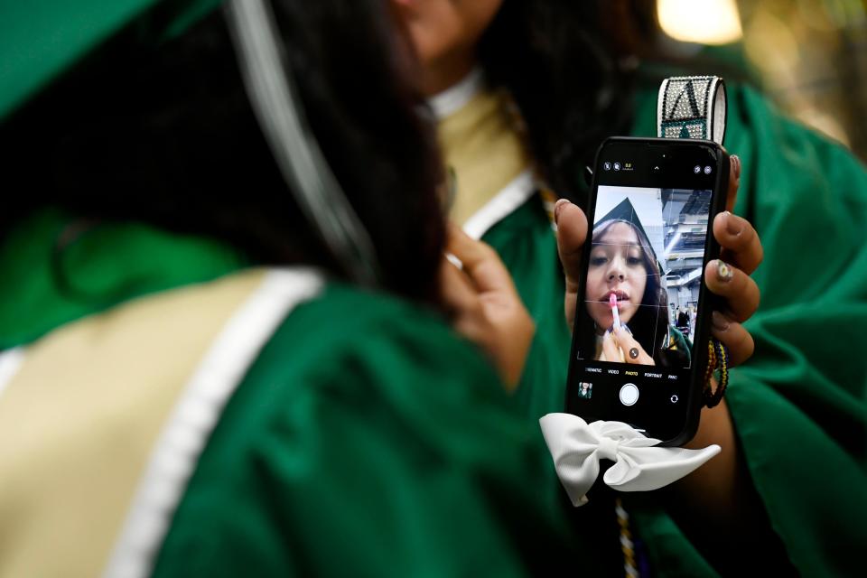 Esperanza Alaniz Perez applies lipgloss in the camera on a friend's phone ahead of Berea High School's 2024 commencement ceremony that was held at Bon Secours Wellness Arena on Monday, May 20, 2024.