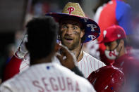 Philadelphia Phillies' Bryce Harper, center, and Jean Segura celebrate in the dugout after Harper's home run against Colorado Rockies pitcher Tyler Kinley during the seventh inning of a baseball game, Saturday, Sept. 11, 2021, in Philadelphia. (AP Photo/Matt Slocum)