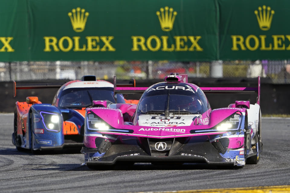 Simon Pagenaud, right, of France, leads Kay van Berlo, of the Netherlands through the International Horseshoe turn during the Rolex 24 hour auto race at Daytona International Speedway, Sunday, Jan. 30, 2022, in Daytona Beach, Fla. (AP Photo/John Raoux)