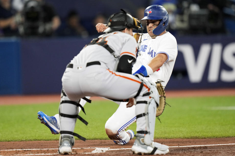 Toronto Blue Jays' Whit Merrifield (15) slides safely into home plate ahead of the throw to San Francisco Giants catcher Patrick Bailey during the first inning of a baseball game Wednesday, June 28, 2023, in Toronto. (Frank Gunn/The Canadian Press via AP)