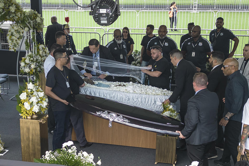 Funeral workers uncover the coffin of the late Brazilian soccer great Pele as he lies in state on the pitch during his wake at Vila Belmiro stadium in Santos, Brazil, Monday, Jan. 2, 2023. (AP Photo/Matias Delacroix)