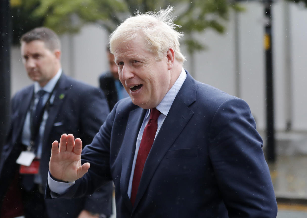 Britain's Prime Minister Boris Johnson rushes through the rain during the Conservative Party Conference in Manchester, England, Tuesday, Oct. 1, 2019. Boris Johnson said Tuesday that his government prepared at last to make firm proposals for a new divorce deal with the European Union. Britain is due to leave the 28-nation bloc at the end of this month, and EU leaders are growing impatient with the U.K.'s failure to set out detailed plans for maintaining an open border between Northern Ireland and Ireland — the key sticking point to a deal. (AP Photo/Frank Augstein)
