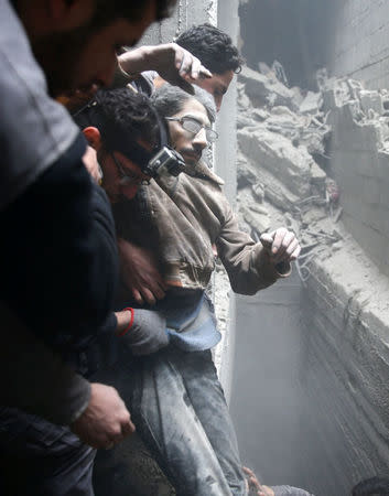 Civil defence help a man from a shelter in the besieged town of Douma in eastern Ghouta in Damascus, Syria, February 22, 2018. REUTERS/Bassam Khabieh