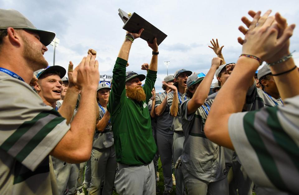 Oakmont baseball head coach Tim Caouette holds the Division 3 state championship trophy after the Spartans beat Medfield in 12 innings at Polar Park Friday, June 16, 2023.