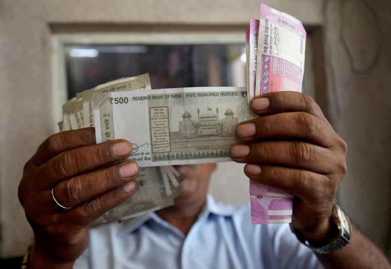 A cashier checks Indian rupee notes inside a room at a fuel station in Ahmedabad